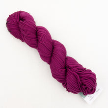 Load image into Gallery viewer, A skein of magenta Plymouth DK Merino Superwash yarn on a white background.