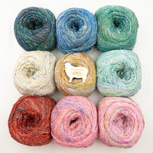Load image into Gallery viewer, A collection of skeins of Noro Kakigori yarn in various colors arranged in a grid pattern.