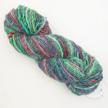 Load image into Gallery viewer, A green, blue, red, and grey skein of variegated Noro Kochoran yarn on a white background.