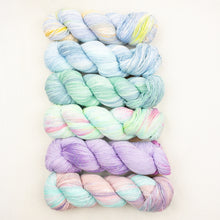 Load image into Gallery viewer, Araucania Huasco Cotón Glisten yarn in pastel colors including blue, green, pink, and purple, arranged vertically on a light background.
