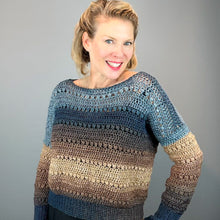 Load image into Gallery viewer, A smiling woman wearing a crocheted long-sleeve sweater with horizontal stripes in blue, brown, and beige, posed against a solid gray studio background.
