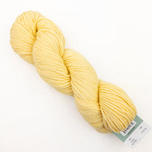 Load image into Gallery viewer, A skein of light yellow Plymouth DK Merino Superwash yarn on a white background.
