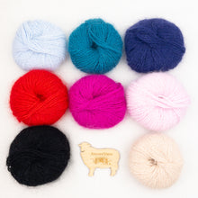 Load image into Gallery viewer, Eight skeins of Plymouth Angora yarn in assorted colors arranged on a white background, including light blue, teal, navy, red, magenta, pale pink, black, beige, and a small wooden logo shaped like a sheep with the text 'Atelier Yarns.'.
